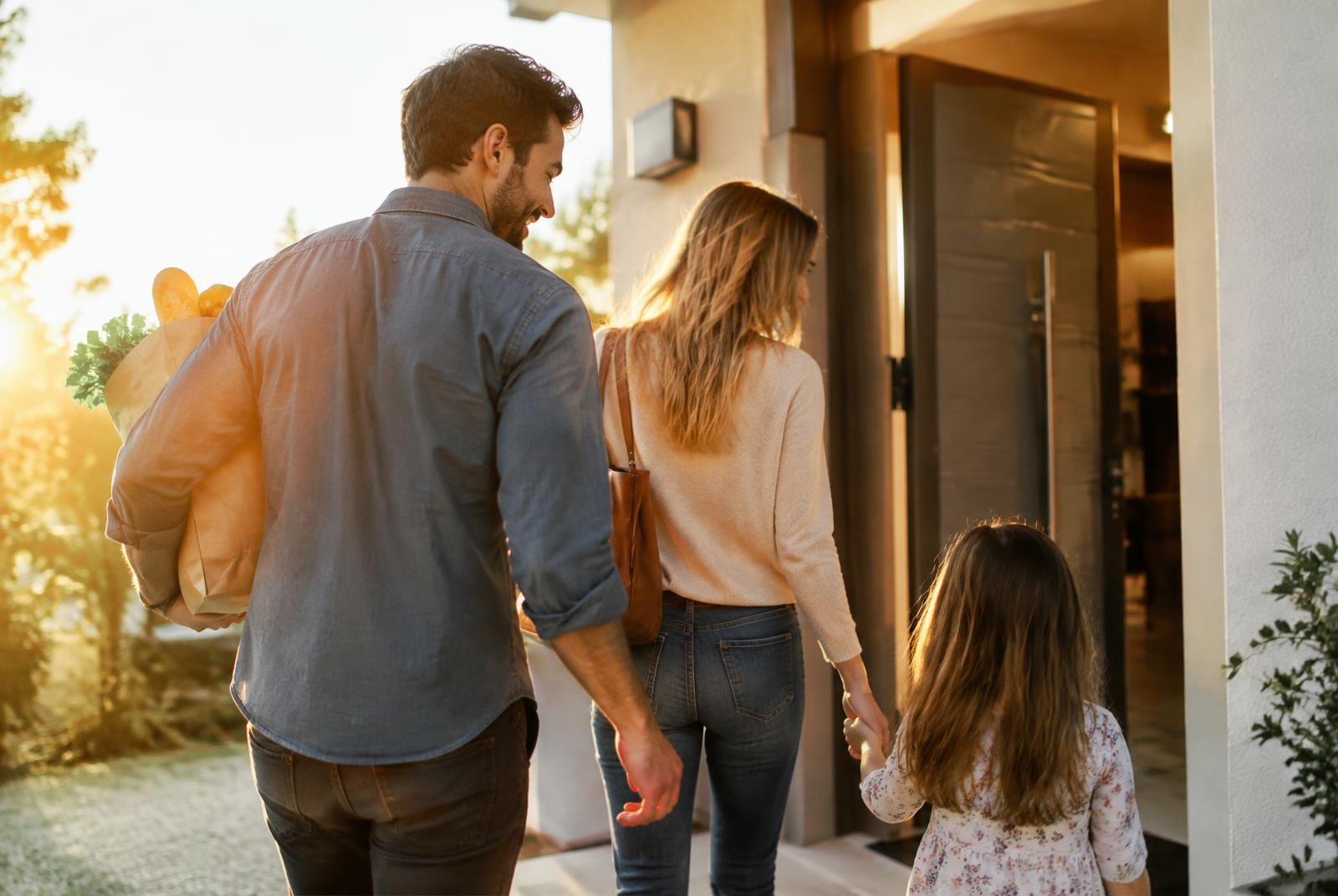 Family arriving home together at their front door
